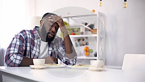 Tired African-American man having headache after hard day, feeling exhausted