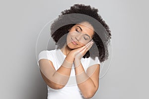 Tired african american millennial lady put head on folded hands.