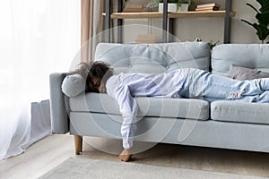 Tired African American woman sleep on sofa at home