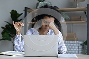 Tired African American woman worker suffer from headache
