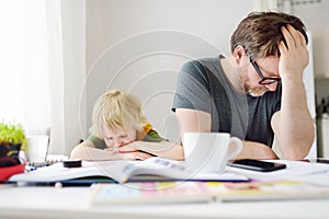 Tired and angry father trying help son doing his homework, but bored child refusing. Homeschooling, online studying, remote