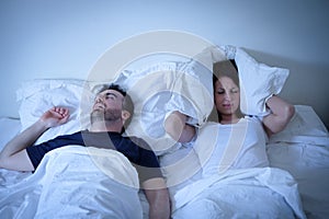 Tired and annoyed woman of her boyfriend snoring in bed