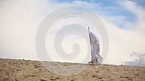 Tired Arab falling on sand in desert, concept of difficulties on road to success