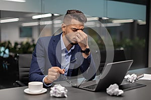 Tired arab guy CEO working on laptop at office