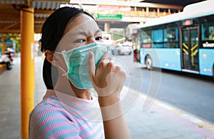 Tired asian child girl cough wearing hygienic mask,stressed worried about air pollution problems,toxic fumes,PM 2.5,dust,bad