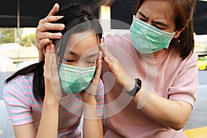 Tired asian child girl crying with hygienic mask suffer from headache and air pollution,allergy to dust,feel sick,dizzy,people