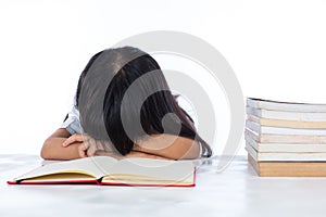 Tired Asian Chinese little girl lying on desk with books