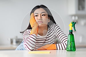 Tired asian lady with dust cloth, copy space