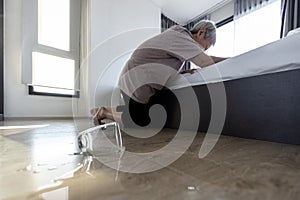 Tired asian senior woman trying to help herself stand up after falling down symptoms of vertigo illness,meniereâ€™s disease,feel