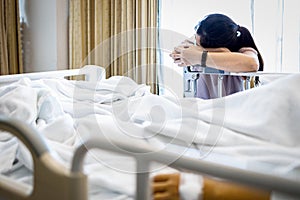 Tired asian woman fell asleep at the beside a patient in a hospital bed physical fatigue caused by overwork or stress of caring