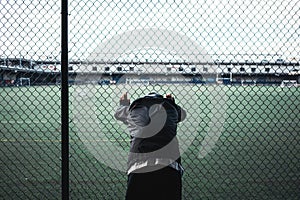 Tired athlete man leaned and holding on to the rabitz fence