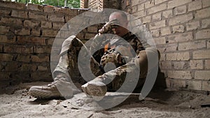 Tired after battle army soldier sitting on ground