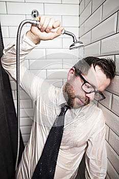 A tired bearded man with glasses, a shirt and a tie, closed his