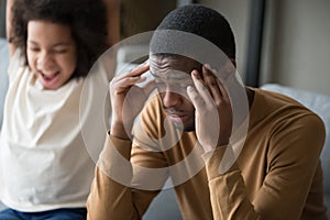 Tired black dad suffer from headache and disobedient daughter