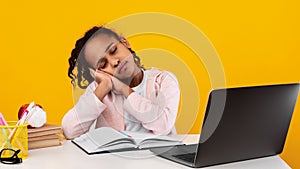 Tired black girl sitting at desk and sleeping