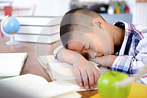 Tired and bored boy sleeping among the books