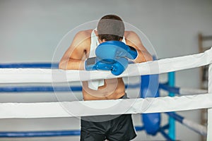 Tired boxer resting in boxing ring