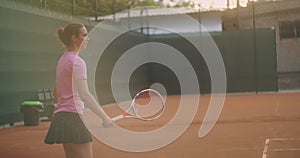 A tired brunette female tennis player walks along the tennis court recuperating and concentrating. Break in a tennis