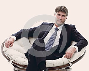 Tired business man sitting in a large comfortable chair