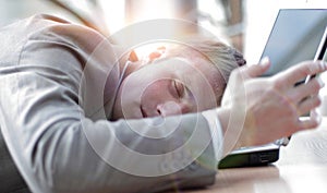 A tired business man sleeping on his laptop at the office