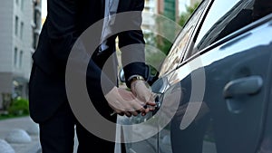 Tired business person locking car with keys, returning home from work, busy man