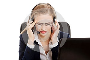 Tired business woman at call center sitting by the table.