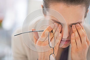 Tired business woman with eyeglasses in office