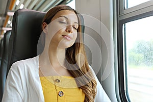 Tired business woman sleeping sitting in the train after a day of work . Train passenger traveling sitting relaxed and sleeping