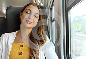Tired business woman sleeping sitting in the train after a day of work . Train passenger traveling sitting relaxed and sleeping