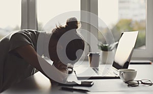 Tired business woman sleeping on table in office. Young overworked exhausted girl working from home. photo