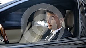 Tired businessman with closed eyes sitting in car, feeling sleepiness, insomnia