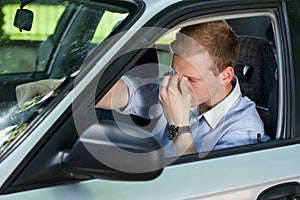 Tired businessman driving a car