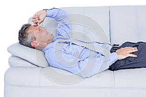 Tired businessman lying on the sofa