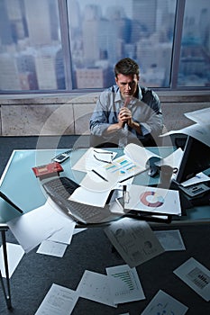 Tired businessman with papers all around