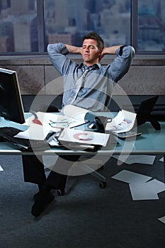 Tired businessman with papers all around