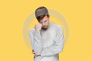 Tired businessman or The serious young man over yellow studio background with headache emotions