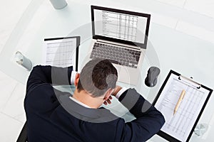 Tired businessman sleeping while calculating expenses in office