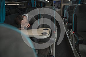 Tired Businessman Sleeping on Coach Bus Table