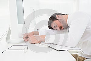 Tired businessman sleeping on keyboard