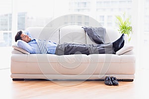 Tired businessman sleeping on a sofa