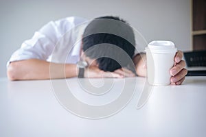 Tired businessman sleeping at work in modern office with hand ho