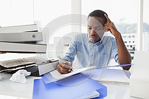 Tired businessman writing notes at desk