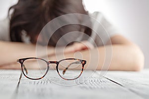 Tired businesswoman falling asleep at her workplace with eyes glasses, The Business Women feel discouraged Holding glasses