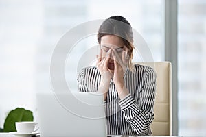 Tired businesswoman massaging eyes feeling strain fatigue headache relieving pain