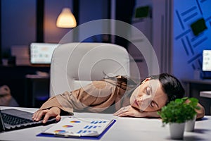 Tired businesswoman resting head on desk