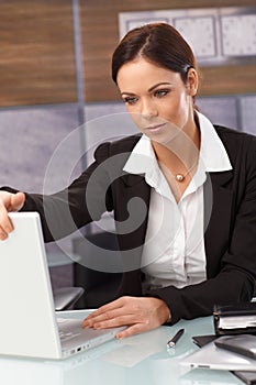 Tired businesswoman shutting down laptop photo