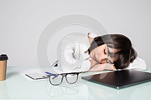 Tired businesswoman sleeping on the desk, in front of the computer screen