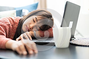 Tired businesswoman sleeping on table in office.