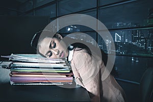 Tired businesswoman sleeps in a document heap