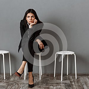 tired businesswoman in suit looking away while waiting